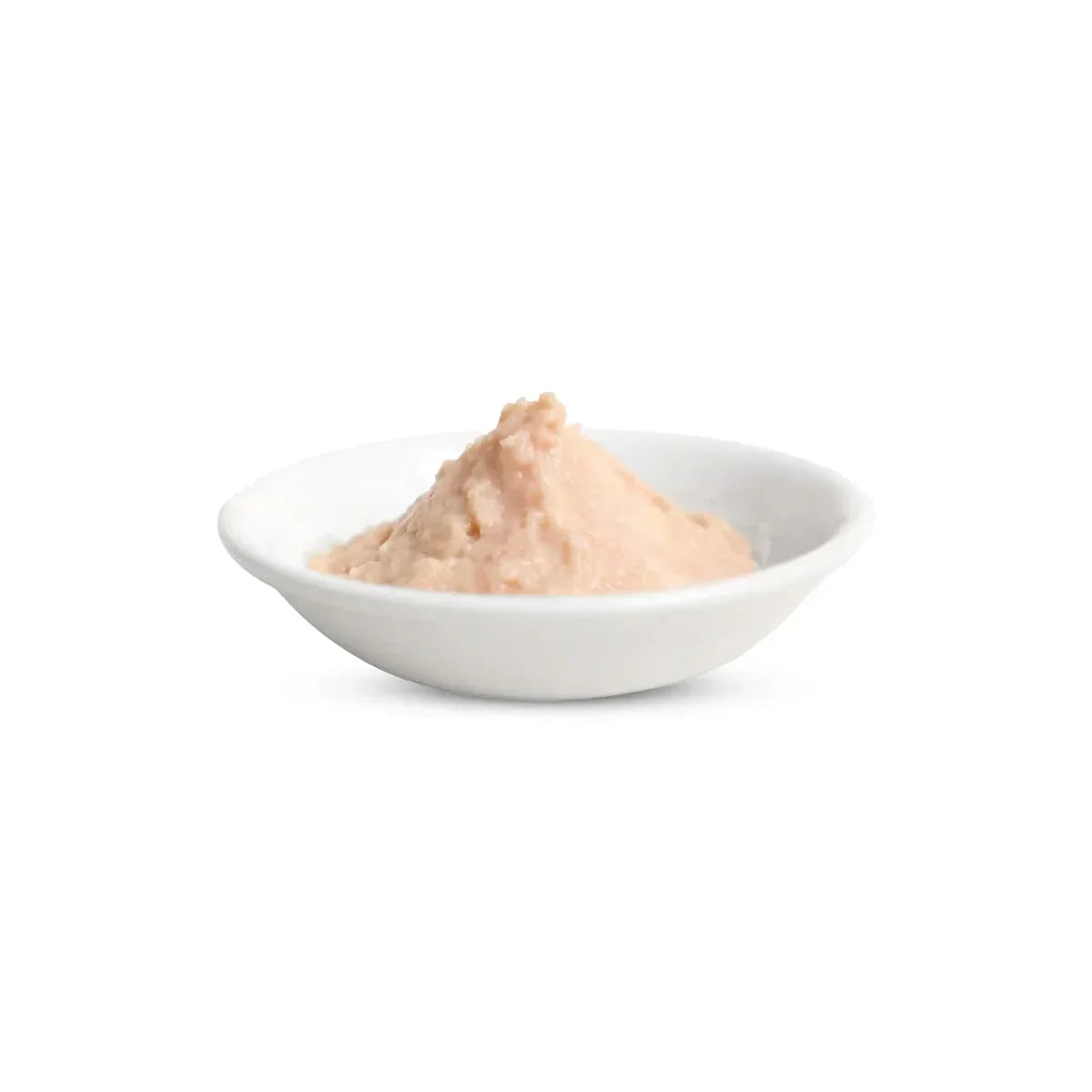 White bowl with a mound of smooth pinkish sauce or paste on white background, zigly