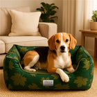 Beagle dog resting on a green zigly leaf-patterned dog bed in a cozy living room