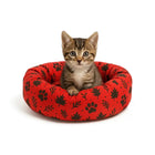 Cute tabby kitten sitting in a red bed with black paw and leaf prints, zigly pet comfort