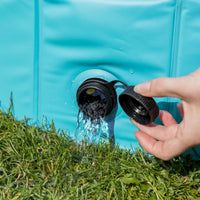 Hand opening black spout on turquoise water container pouring water onto green grass zigly