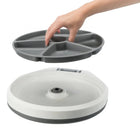 Hand placing gray segmented tray onto white automatic pet feeder base with digital display, zigly