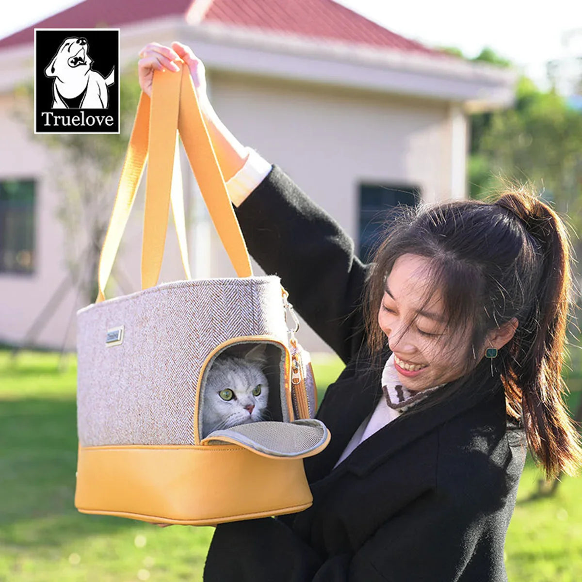 Woman holding a zigly Truelove stylish cat carrier bag with a white cat inside outdoors