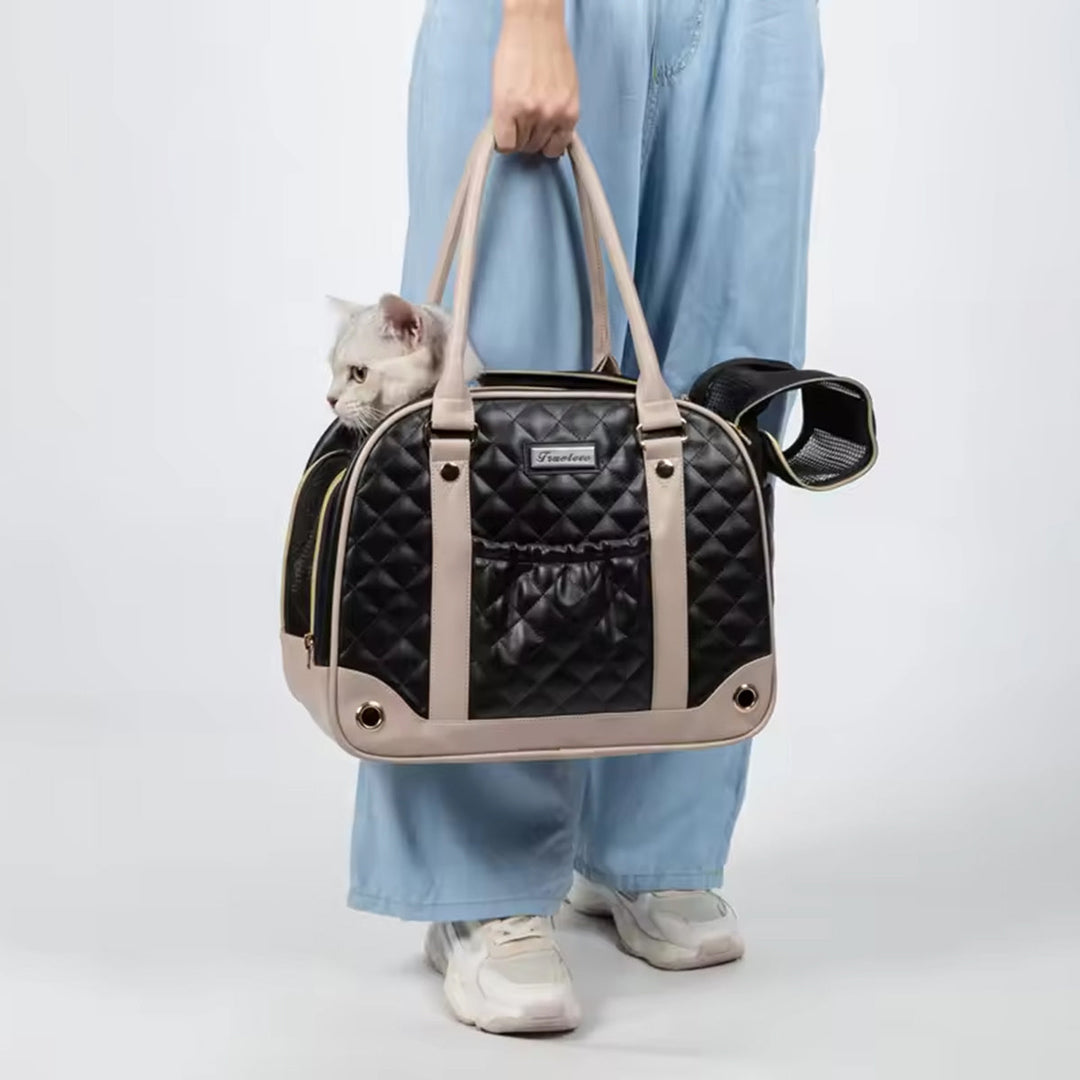 Person holding black and beige zigly quilted pet carrier bag with gray cat inside