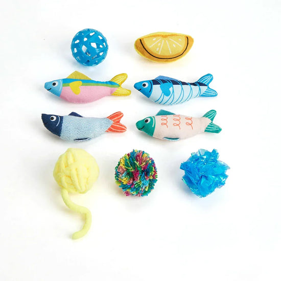 Zigly colorful cat toys including fabric fish, yarn balls, lemon slice, and plastic ball on white background
