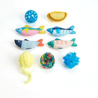 Zigly colorful cat toys including fabric fish, yarn balls, lemon slice, and plastic ball on white background