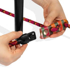 Hands connecting purple and orange zigly rope with black plastic clip and colorful wooden toggle