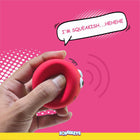 Hand squeezing a red rubber squishy toy with eyes saying I'm squeakish on pink background, zigly
