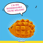 Orange hedgehog-shaped biodegradable toy with zigly pattern on blue background
