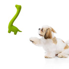 Zigly white and tan Shih Tzu puppy reaching for green dinosaur chew toy on white background