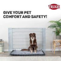 Brown dog sitting inside open wire crate on gray mat with Trixie logo, zigly comfort and safety